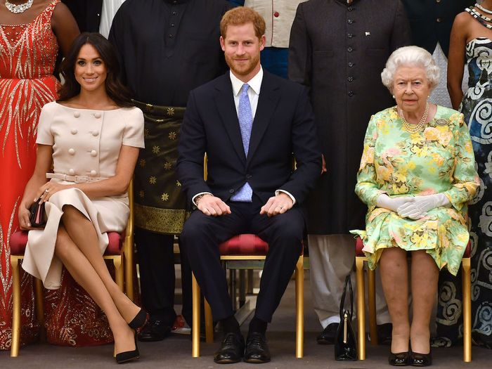 Prince Harry and Meghan Markle seated alongside the Queen at an event