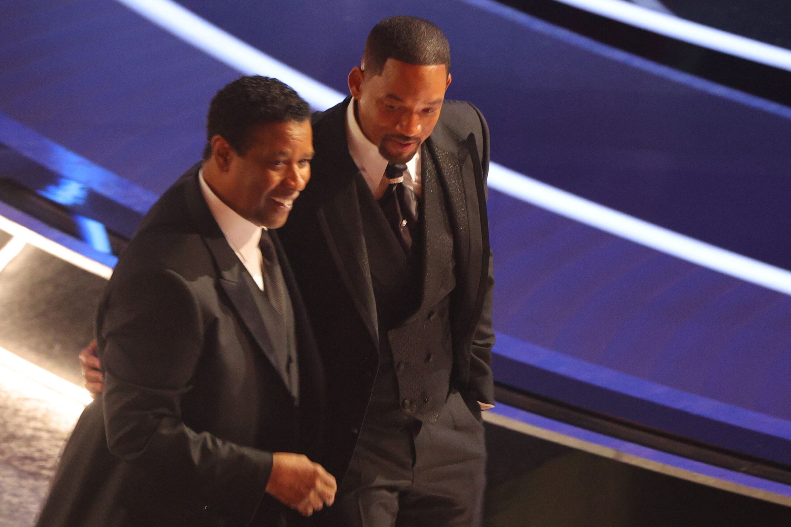 Denzel Washington walks with Will Smith after he hit Chris Rock
